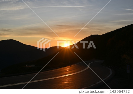 Winding Mountain Road at Sunset with Sunstar Winding Mountain Road at Sunset with Sunstar 142964722