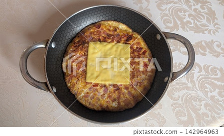 Homemade round omelet with sliced cheese on top inside a frying pan Homemade round omelet with sliced cheese on top inside a frying pan 142964963