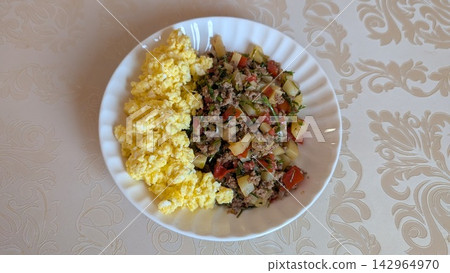 Homemade breakfast with scrambled eggs and minced meat stir fry on a white plate Homemade breakfast with scrambled eggs and minced meat stir fry on a white plate 142964970