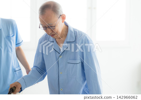 一位拄著拐杖的老人和一位護理人員 一位拄著拐杖的老人和一位護理人員 142966062