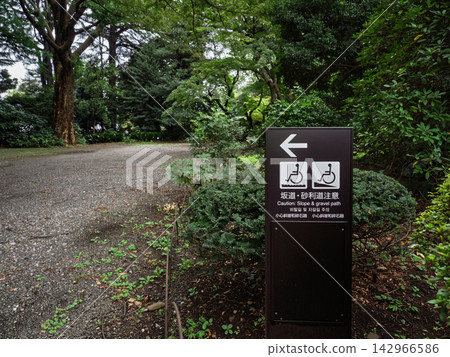 A wheelchair-accessible sign warning of "Slopes and gravel paths" is installed on the park's pathways. A wheelchair-accessible sign warning of "Slopes and gravel paths" is installed on the park's pathways. 142966586