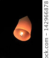 Single Glowing Paper Sky Lantern Floating High in the Dark Night Sky 142966878