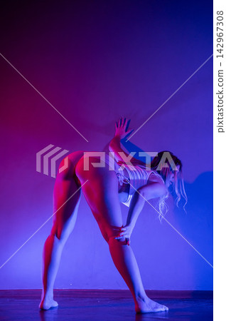 Young woman twerking in neon light. Young woman twerking in neon light. 142967308