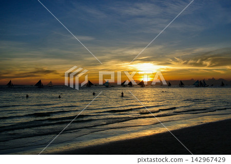 Tropical Sunset Seascape with Silhouettes of Sailing Boats and a Child Tropical Sunset Seascape with Silhouettes of Sailing Boats and a Child 142967429