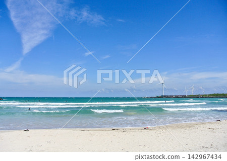 Coastal Landscape with Turquoise Waves, White Sand, and Wind Turbines Coastal Landscape with Turquoise Waves, White Sand, and Wind Turbines 142967434