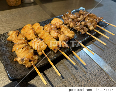 A platter of grilled chicken skewers, fragrant and delicious, served at an izakaya (Japanese pub). A platter of grilled chicken skewers, fragrant and delicious, served at an izakaya (Japanese pub). 142967747