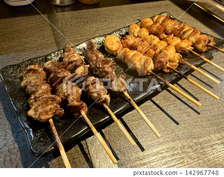A platter of grilled chicken skewers, fragrant and delicious, served at an izakaya (Japanese pub). A platter of grilled chicken skewers, fragrant and delicious, served at an izakaya (Japanese pub). 142967748