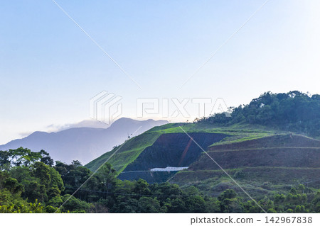Golden colorful sunrise behind the tropical mountain mountains in Brazil. Golden colorful sunrise behind the tropical mountain mountains in Brazil. 142967838