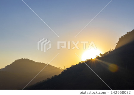 Golden colorful sunrise behind the tropical mountain mountains in Brazil. Golden colorful sunrise behind the tropical mountain mountains in Brazil. 142968082
