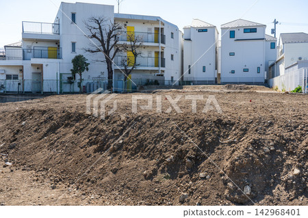 住宅區內一塊正在興建中的土地,上面堆滿了泥土。 住宅區內一塊正在興建中的土地,上面堆滿了泥土。 142968401