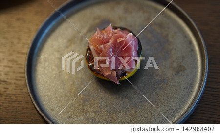 一道絕佳的開胃菜,烤無花果配義大利燻火腿,盛放在精緻的盤子裡。 一道絕佳的開胃菜,烤無花果配義大利燻火腿,盛放在精緻的盤子裡。 142968402