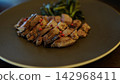 一道主菜是鮮嫩多汁的烤羊肉，佐以粉紅胡椒粒。 142968411
