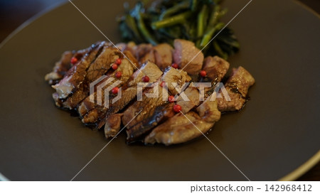 一道主菜是鮮嫩多汁的烤羊肉,佐以粉紅胡椒粒。 一道主菜是鮮嫩多汁的烤羊肉,佐以粉紅胡椒粒。 142968412