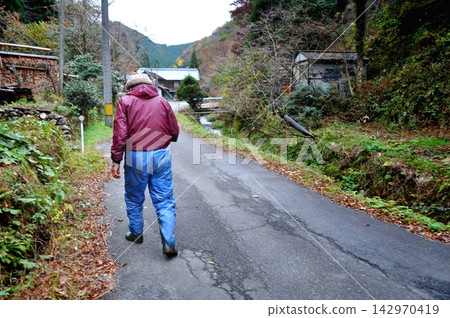 Senior man walking through a remote village Senior man walking through a remote village 142970419