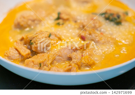 Creamy chicken curry stew in blue bowl with herbs and spices Creamy chicken curry stew in blue bowl with herbs and spices 142971699