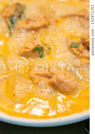 Creamy chicken curry with herbs and chili, close up food texture 142971701