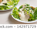 Creamy romaine salad with grilled chicken and dressing served on white plate 142971729