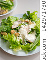 Caesar salad, lettuce, chicken, creamy dressing on white plate 142971730