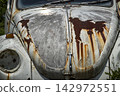 A severely dilapidated abandoned car 142972551