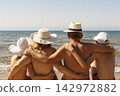 Family in hats at the beach 142972882