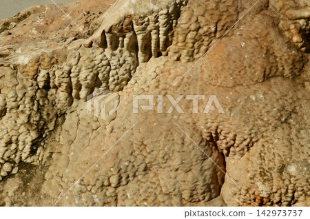 Flowstone, a type of cave formation created by thin sheets of mineral-rich water flowing down walls or floors.on: Water carrying dissolved minerals, usually calcite, drips or flows over cave surfaces. Flowstone, a type of cave formation created by thin sheets of mineral-rich water flowing down walls or floors.on: Water carrying dissolved minerals, usually calcite, drips or flows over cave surfaces. 142973737