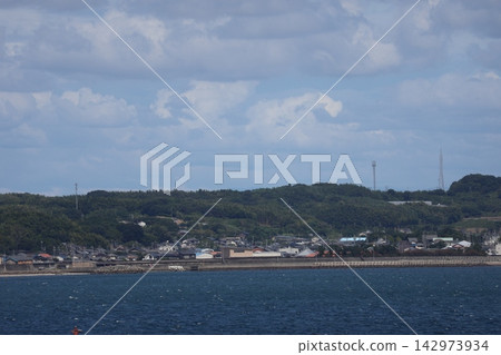 A landscape of the blue ocean, breakwater, townscape, mountains, clouds, and blue sky. A landscape of the blue ocean, breakwater, townscape, mountains, clouds, and blue sky. 142973934