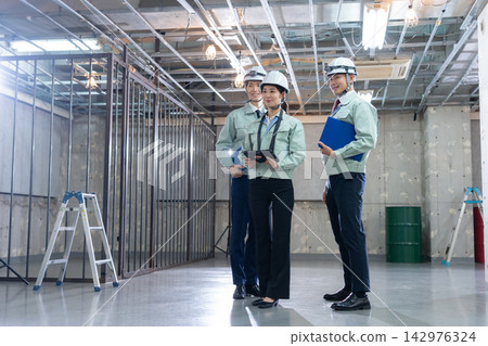 Construction workers and architects having a meeting at the construction site. 142976324