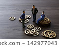 Miniature business people discussing teamwork and strategy planning 142977043