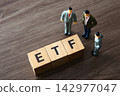 Business figurines discussing etf investment strategy on wooden table 142977047