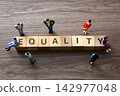 Miniature figures discussing equality concept on wooden blocks 142977048