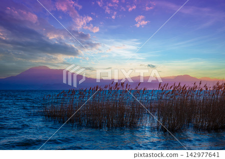 Early morning, sunrise over the lake. Garda lake (Lago di Garda), Italy, Europe Early morning, sunrise over the lake. Garda lake (Lago di Garda), Italy, Europe 142977641