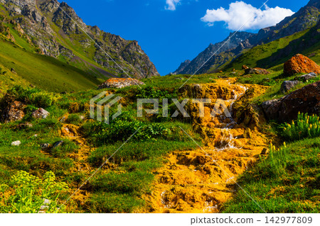 Vibrant Mineral Waterfall in Mountainous Kyrgyzstan Landscape 142977809