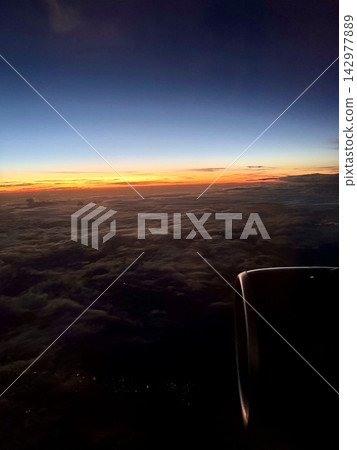 The sunrise sky as seen from inside the airplane The sunrise sky as seen from inside the airplane 142977889