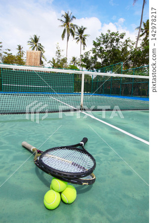 Tennis Rackets and Balls on Tropical Outdoor Court Tennis Rackets and Balls on Tropical Outdoor Court 142978217