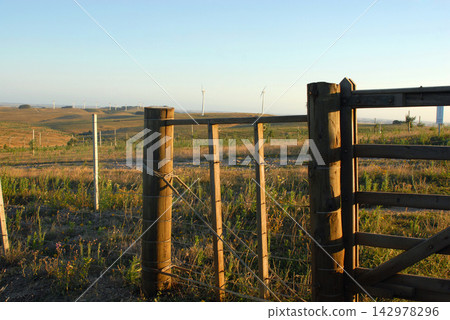 Wind Farm Landscape with Rural Fence at Golden Hour Wind Farm Landscape with Rural Fence at Golden Hour 142978296