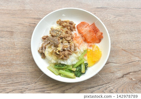grilled pork with Bulgogi sauce Korean food with kimchi dressing slice yellow pickled radish topping rice on plate grilled pork with Bulgogi sauce Korean food with kimchi dressing slice yellow pickled radish topping rice on plate 142978789