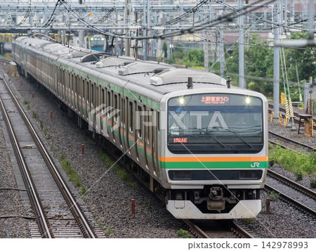 [Tokaido Main Line] A local train passes through the rainy streets of Kamata. 142978993