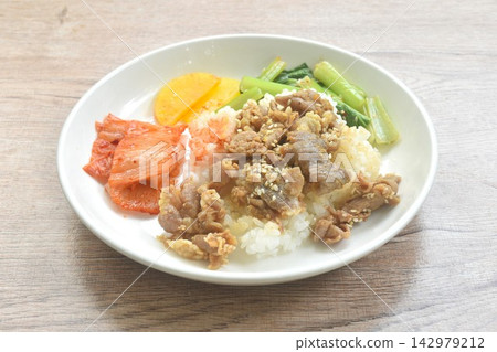 grilled pork with Bulgogi sauce Korean food with kimchi dressing slice yellow pickled radish topping rice on plate grilled pork with Bulgogi sauce Korean food with kimchi dressing slice yellow pickled radish topping rice on plate 142979212