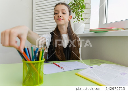High School Student Choosing Pencils While Doing Homework 142979713