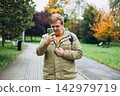 Perplexed man holding cellphone in hands on the street, looking at screen with irritated expression, made a mistake or annoyed by texts and calls. Negative emotion. High quality photo 142979719