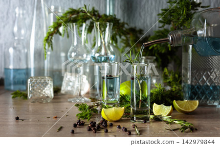 Gin is poured from a bottle into a glass. Gin is poured from a bottle into a glass. 142979844