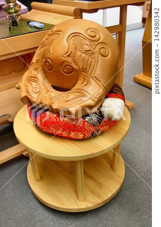 A wooden fish drum (mokugyo) is placed on a cushion in front of the altar. A wooden fish drum (mokugyo) is placed on a cushion in front of the altar. 142980342