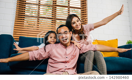 An interracial family shares a heartwarming moment at home playing plane games with their daughter An interracial family shares a heartwarming moment at home playing plane games with their daughter 142980460