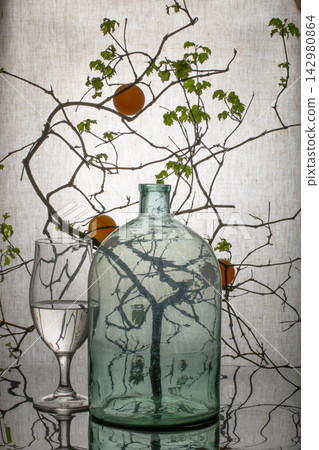 Still life with a glass and a tree branch Still life with a glass and a tree branch 142980864