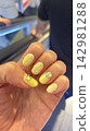 Beautiful fingers with sparkling yellow nail polish 142981288