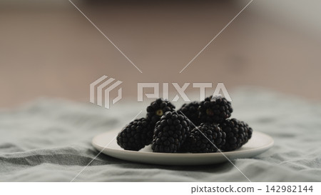 fresh ripe blackberry on a white saucer fresh ripe blackberry on a white saucer 142982144
