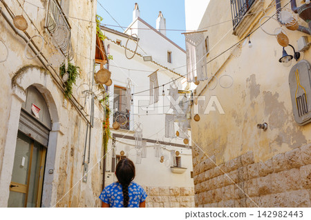 Girl exploring a decorated old town street in Puglia Girl exploring a decorated old town street in Puglia 142982443
