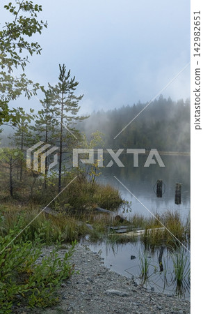 The quiet lake reflects the peaceful beauty of the autumn landscape. The quiet lake reflects the peaceful beauty of the autumn landscape. 142982651