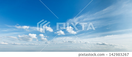 Bright blue sky with fluffy white clouds during a calm day Bright blue sky with fluffy white clouds during a calm day 142983267