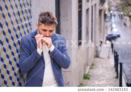 Man plays harmonica outdoors in city street Man plays harmonica outdoors in city street 142983283